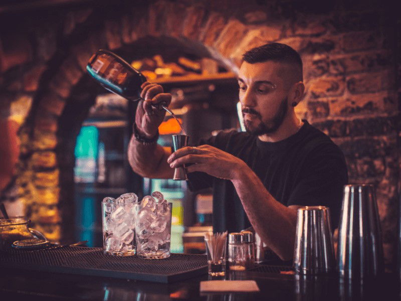 Bartender outfits may be worn more casually by wearing a t-shirt with jeans.